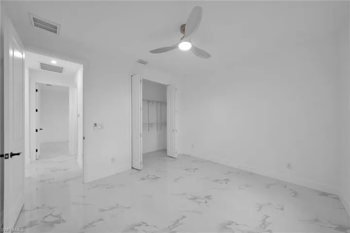 Unfurnished bedroom with ceiling fan and a closet