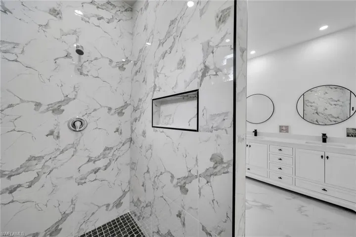 Bathroom with vanity and tiled shower