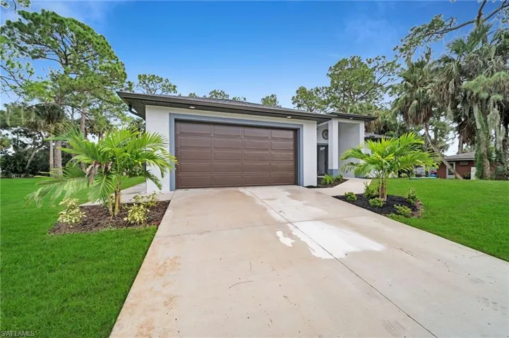 View of front of home featuring a front lawn and a garage