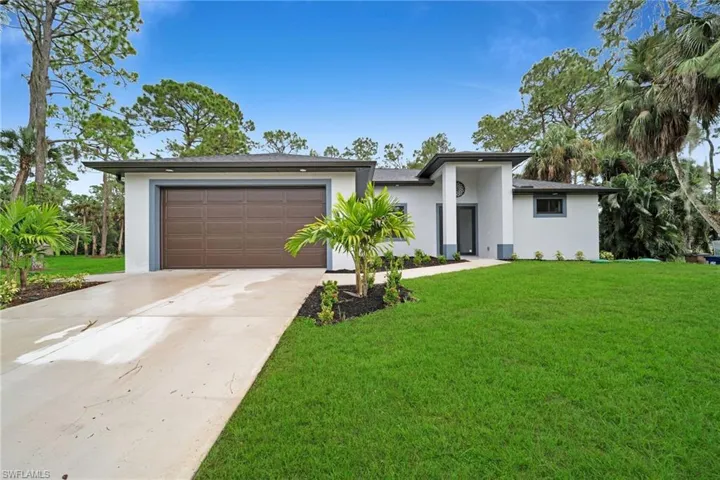 View of front of property featuring a garage and a front yard