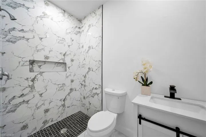 Bathroom with vanity, toilet, and a tile shower