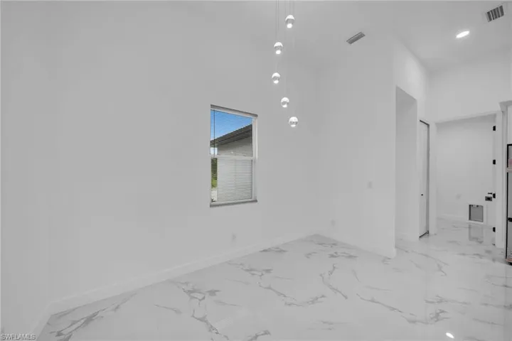 Empty room featuring a towering ceiling
