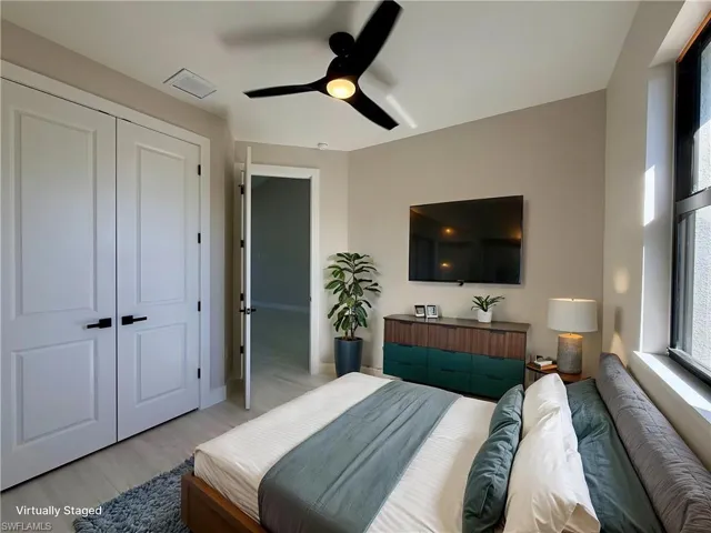 Bedroom featuring ceiling fan, wood finished floors, and a closet
