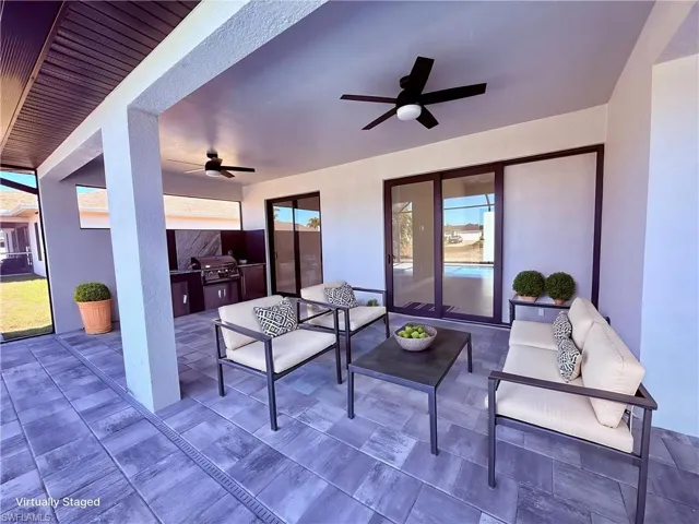View of patio / terrace featuring a ceiling fan and an outdoor kitchen with living area