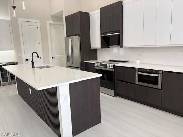 Two tone kitchen with stainless steel appliances, two tone cabinets, modern cabinets, and wine cooler