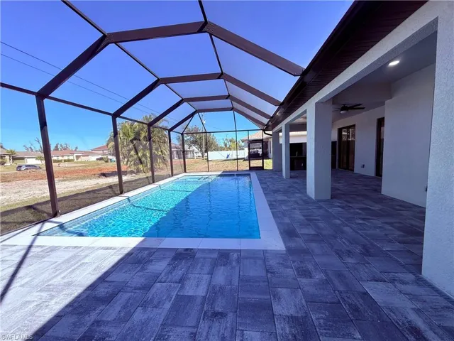 Outdoor pool featuring a sunroom, a patio, and a lanai