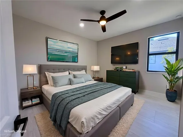 Bedroom with a ceiling fan and light wood-style floors