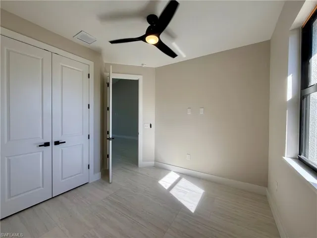 Unfurnished bedroom featuring ceiling fan and a closet