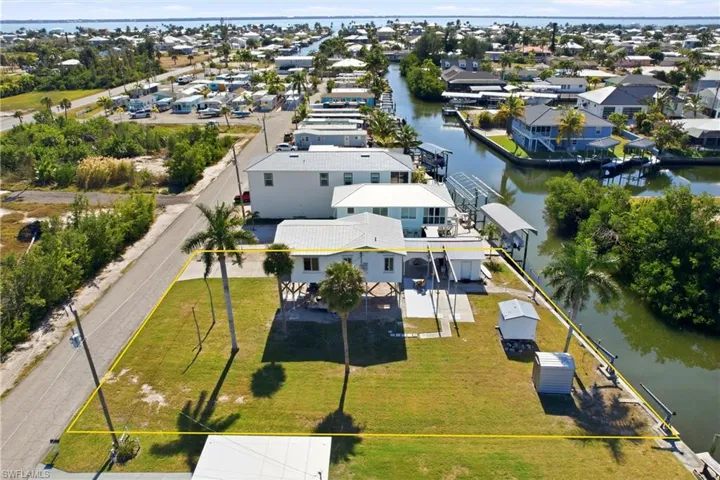 Aerial view of canal to open water.  Home and additional lot shown in yellow.