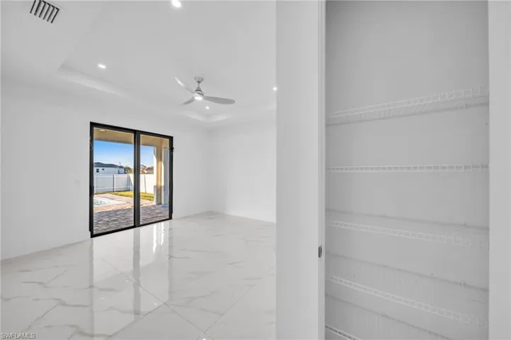 Unfurnished room featuring visible vents, ceiling fan, recessed lighting, marble finish floor, and a raised ceiling