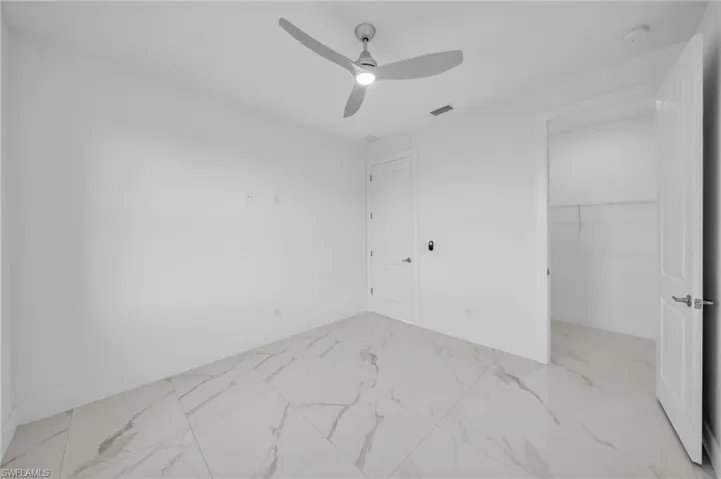 Bedroom with visible vents, marble finish floor, a closet, and ceiling fan
