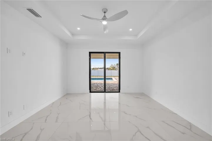 Unfurnished room featuring a ceiling fan, visible vents, baseboards, a raised ceiling, and marble finish floor