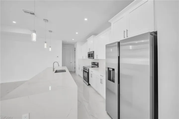 Kitchen with visible vents, a sink, white cabinets, appliances with stainless steel finishes, and marble finish floor