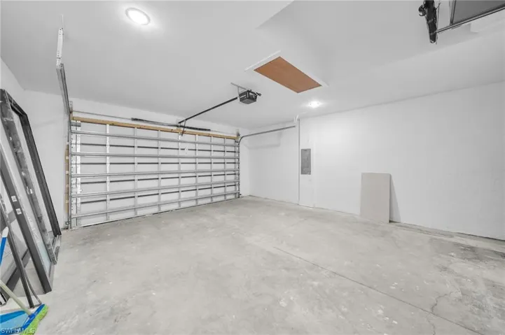 Garage featuring electric panel and a garage door opener