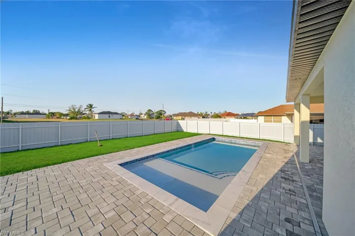 View of pool featuring a yard, a patio, a fenced in pool, and a fenced backyard