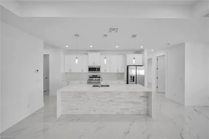 Kitchen featuring visible vents, a spacious island, recessed lighting, a sink, and appliances with stainless steel finishes