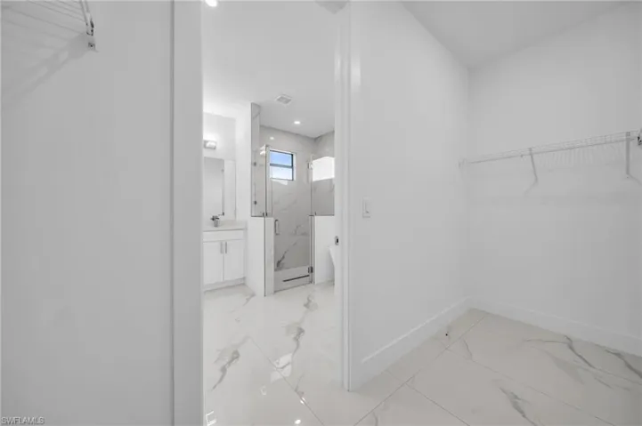 Walk in closet featuring a sink, visible vents, and marble finish floor