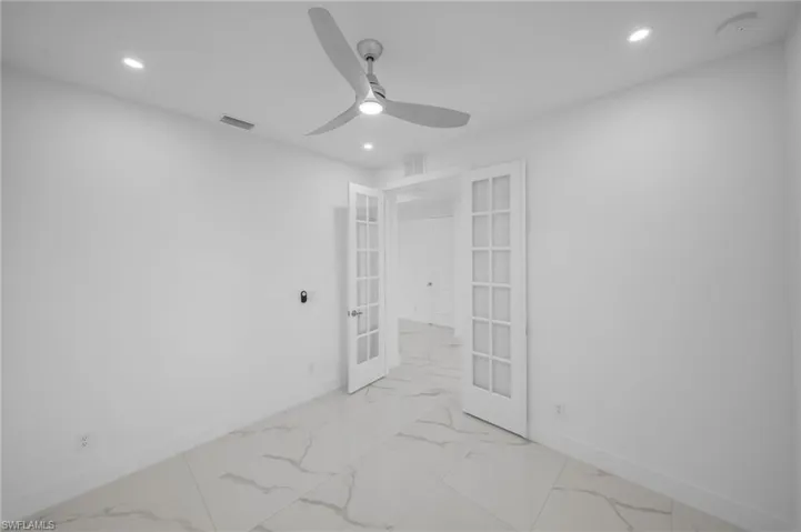 Unfurnished room with french doors, baseboards, marble finish floor, and visible vents