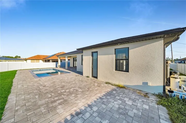 Rear view of property featuring a fenced backyard, stucco siding, a patio, and a fenced in pool