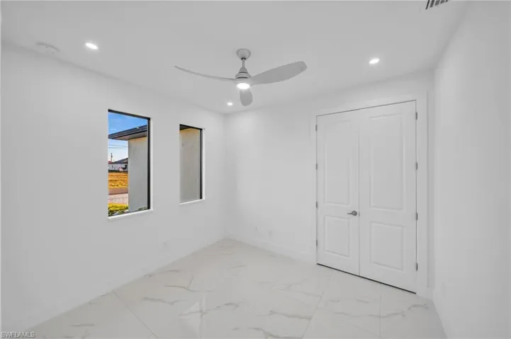 Empty room with recessed lighting, marble finish floor, baseboards, and ceiling fan