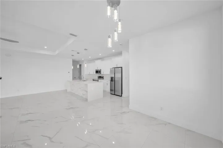 Unfurnished living room featuring recessed lighting, visible vents, marble finish floor, and baseboards