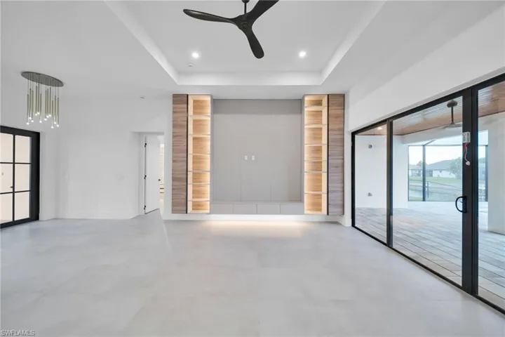 Unfurnished room featuring ceiling fan, recessed lighting, and a tray ceiling