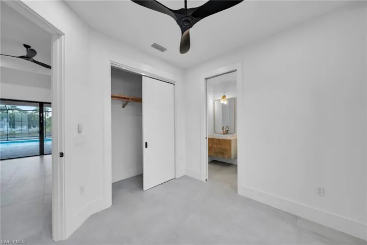 Unfurnished bedroom featuring concrete flooring, a closet, and ensuite bathroom