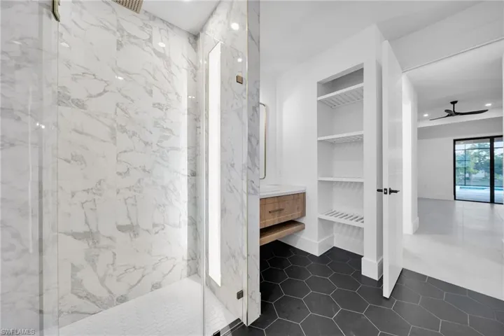 Full bath with a marble finish shower, vanity, recessed lighting, built in features, and a ceiling fan