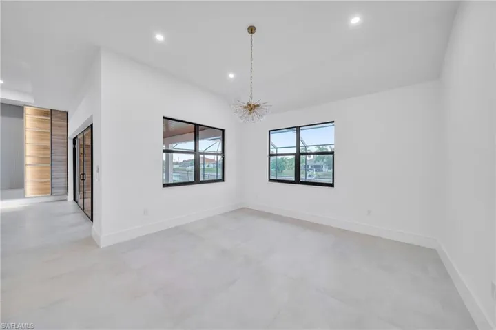 Spare room featuring hanging lights and lofted ceiling