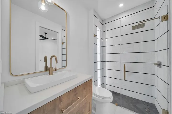 Full bath with vanity, a stall shower, and recessed lighting