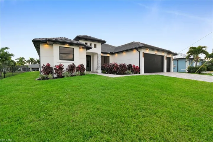 Prairie-style home with decorative driveway, stucco siding, an attached garage, and a tiled roof