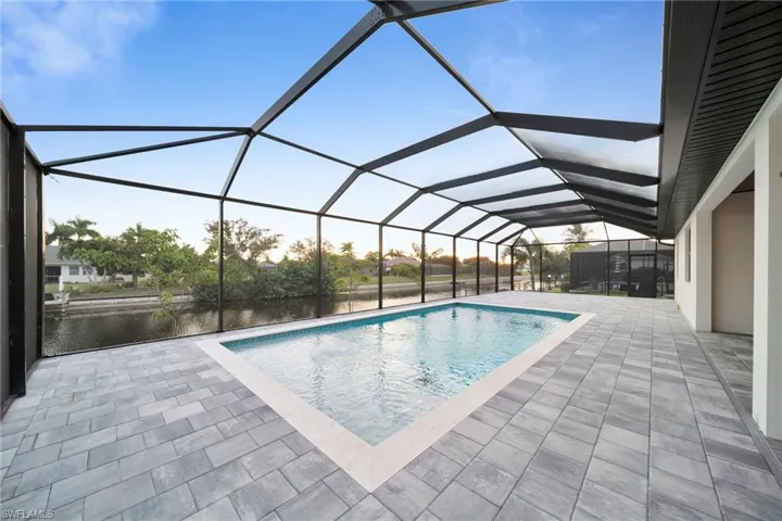 Outdoor pool featuring a sunroom, a lanai, and a patio