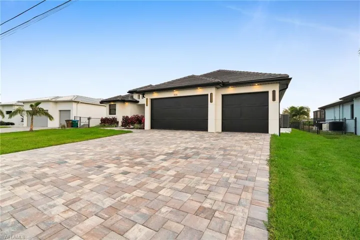 Prairie-style home featuring driveway, an attached garage, and stucco siding