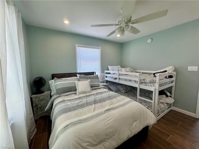Bedroom with ceiling fan and dark hardwood / wood-style floors