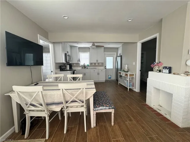 Dining room featuring sink, a brick fireplace, and dark hardwood / wood-style floors