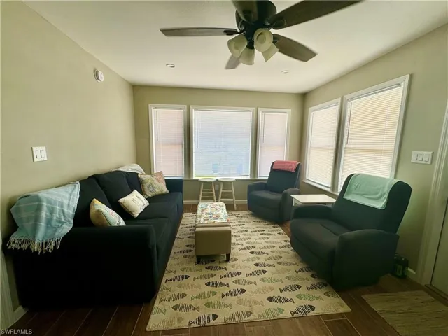 Living room with ceiling fan and wood-type flooring