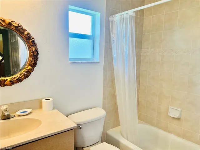 Full bathroom with vanity, toilet, and shower / bath combination with curtain