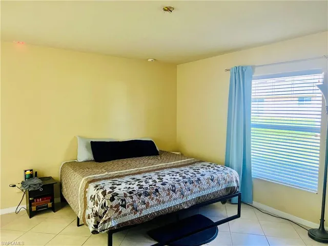 Bedroom with light tile patterned flooring