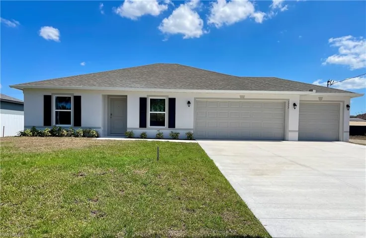 Ranch-style home with an attached garage, a front lawn, stucco siding, concrete driveway, and a shingled roof