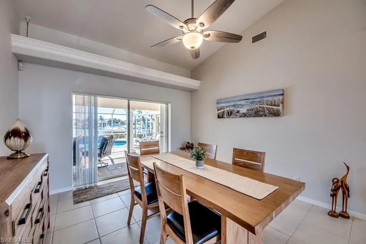 Tiled dining area featuring ceiling fan and lofted ceiling