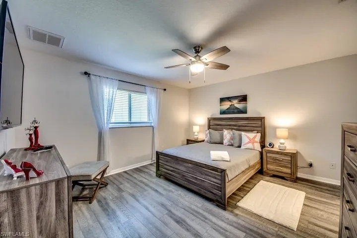 Bedroom with a textured ceiling, light wood-type flooring, and ceiling fan