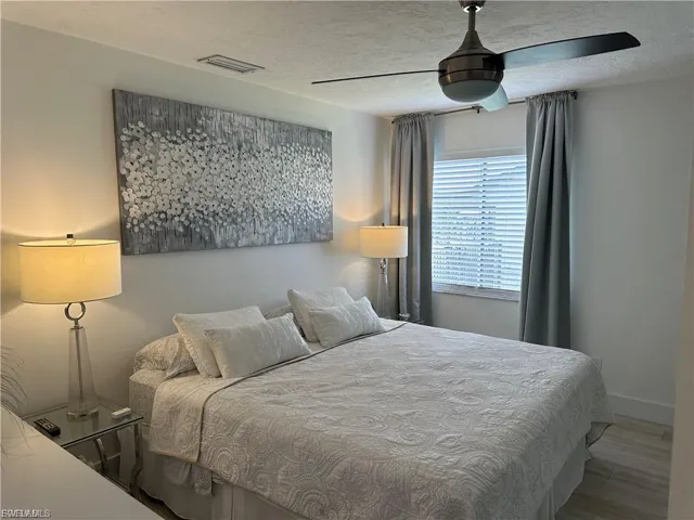 Bedroom with a textured ceiling and wood finished floors