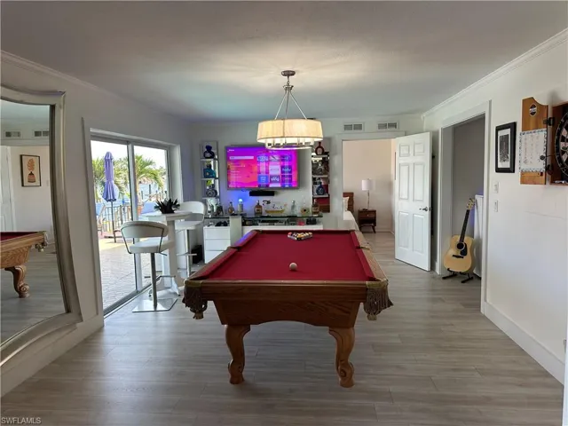 Playroom featuring billiards table, light wood finished floors, and crown molding