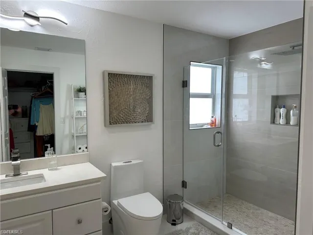 Full bath featuring a stall shower and vanity