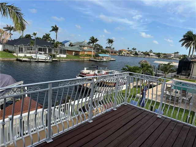 Wooden terrace with a water view, a residential view, and a dock