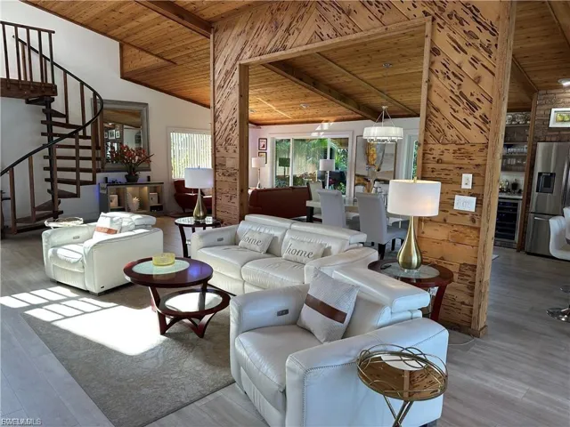 Living area with wood ceiling, wood finished floors, beverage cooler, and vaulted ceiling with beams