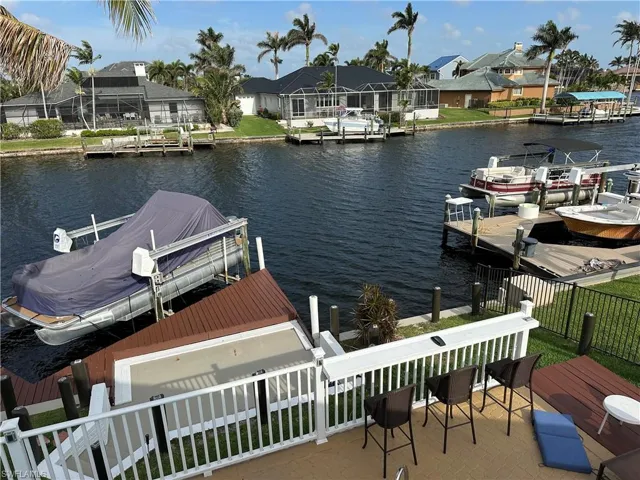 Dock with a water view, a residential view, and boat lift
