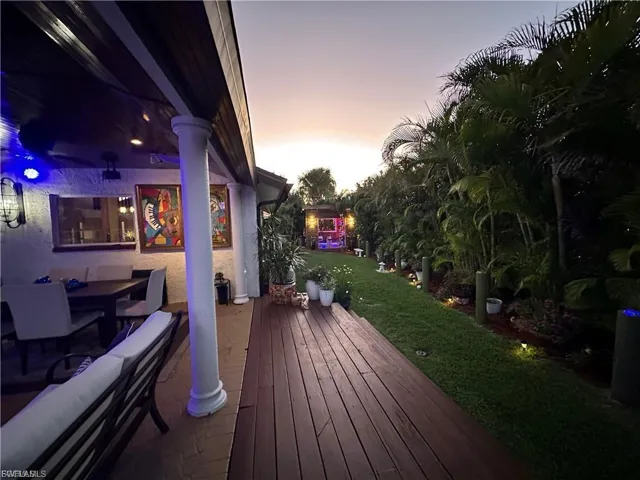 Deck at dusk with a yard and outdoor dining space