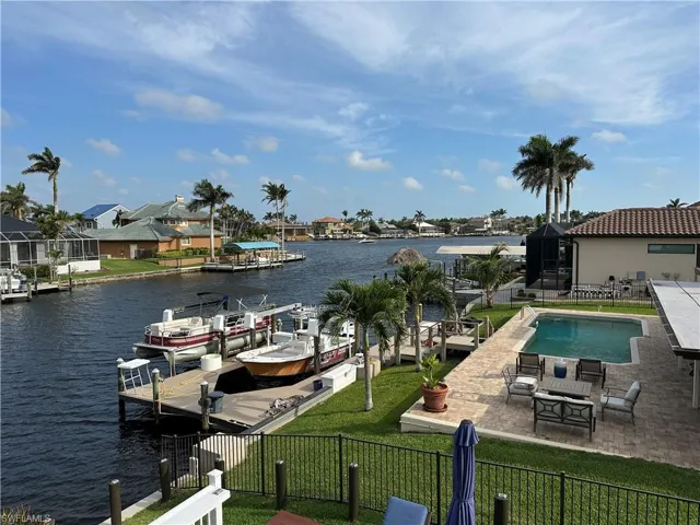 Dock area featuring a water view, a patio, and a residential view