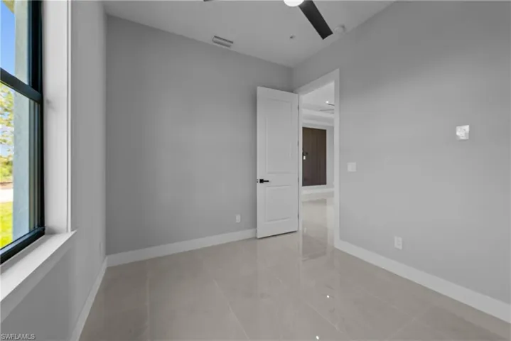 Spare room with plenty of natural light, a ceiling fan, and baseboards